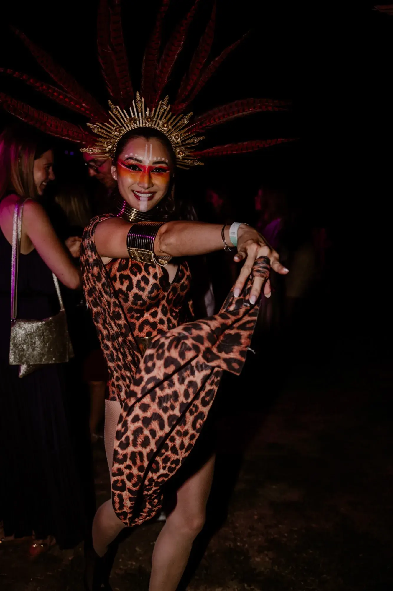 Performance événementielle de nuit, coiffe dorée à plumes rouges