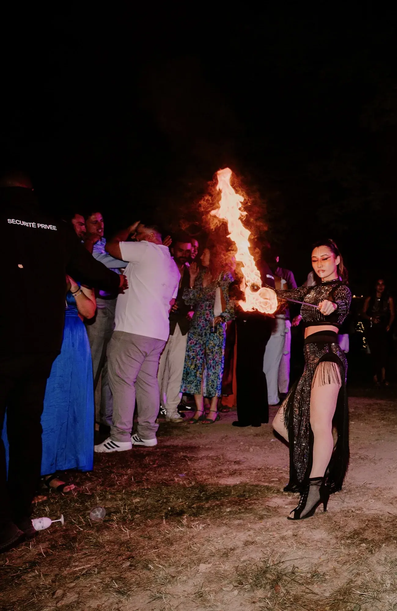 Danse avec éventail enflammé lors d’une soirée en extérieur