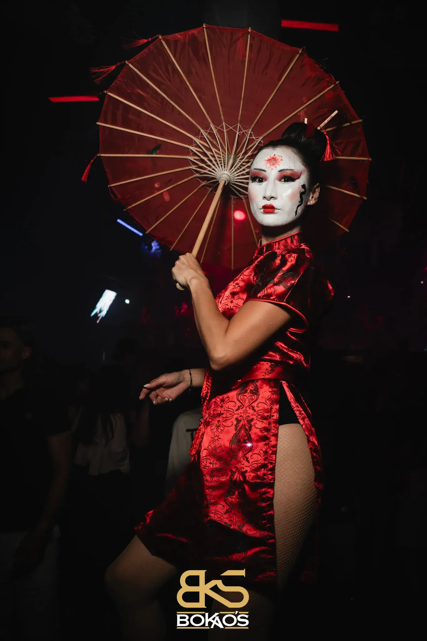 Show sur thème geisha, robe qipao rouge et ombrelle, pose de profil