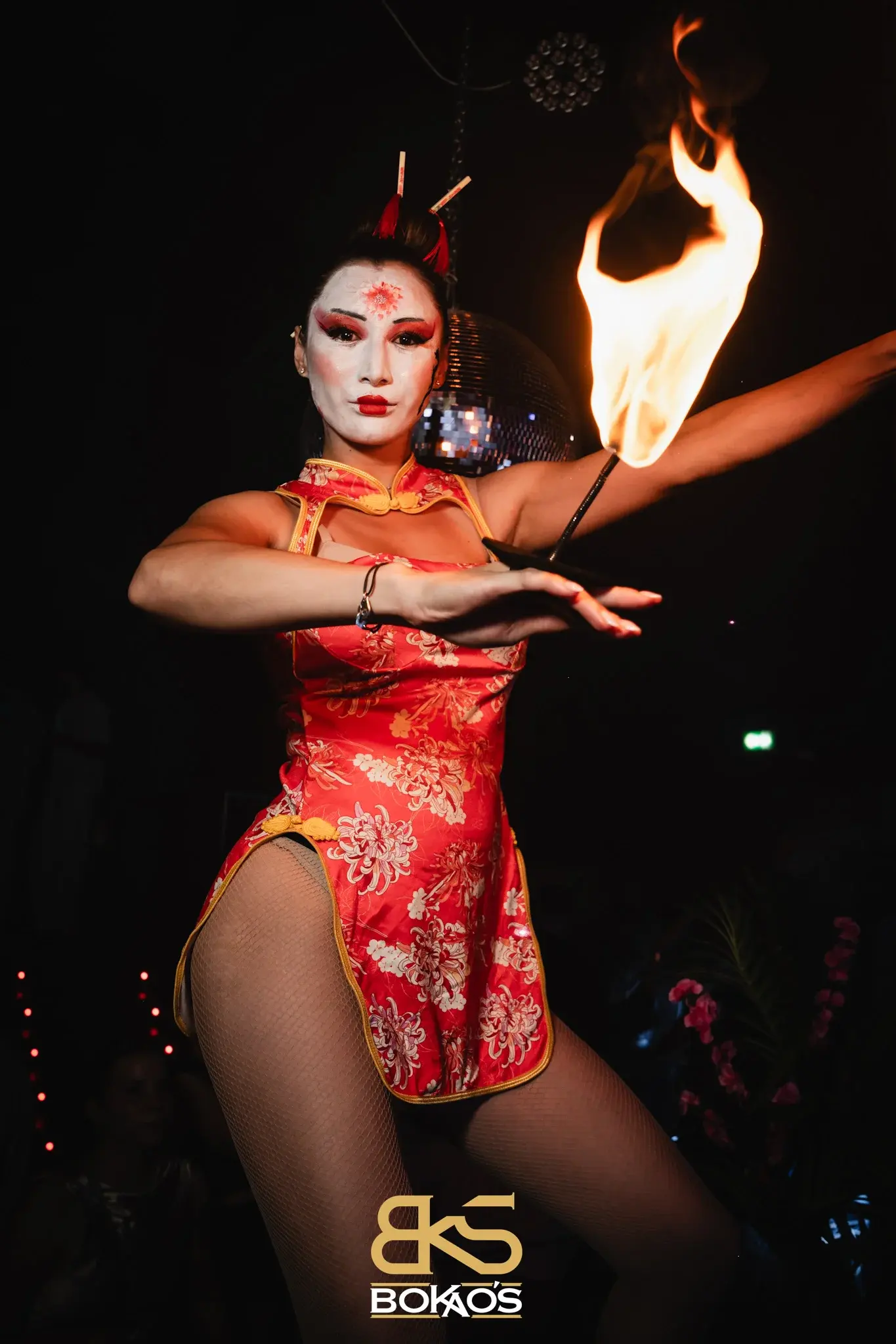 Danse avec feu en club, éventail enflammé tendu