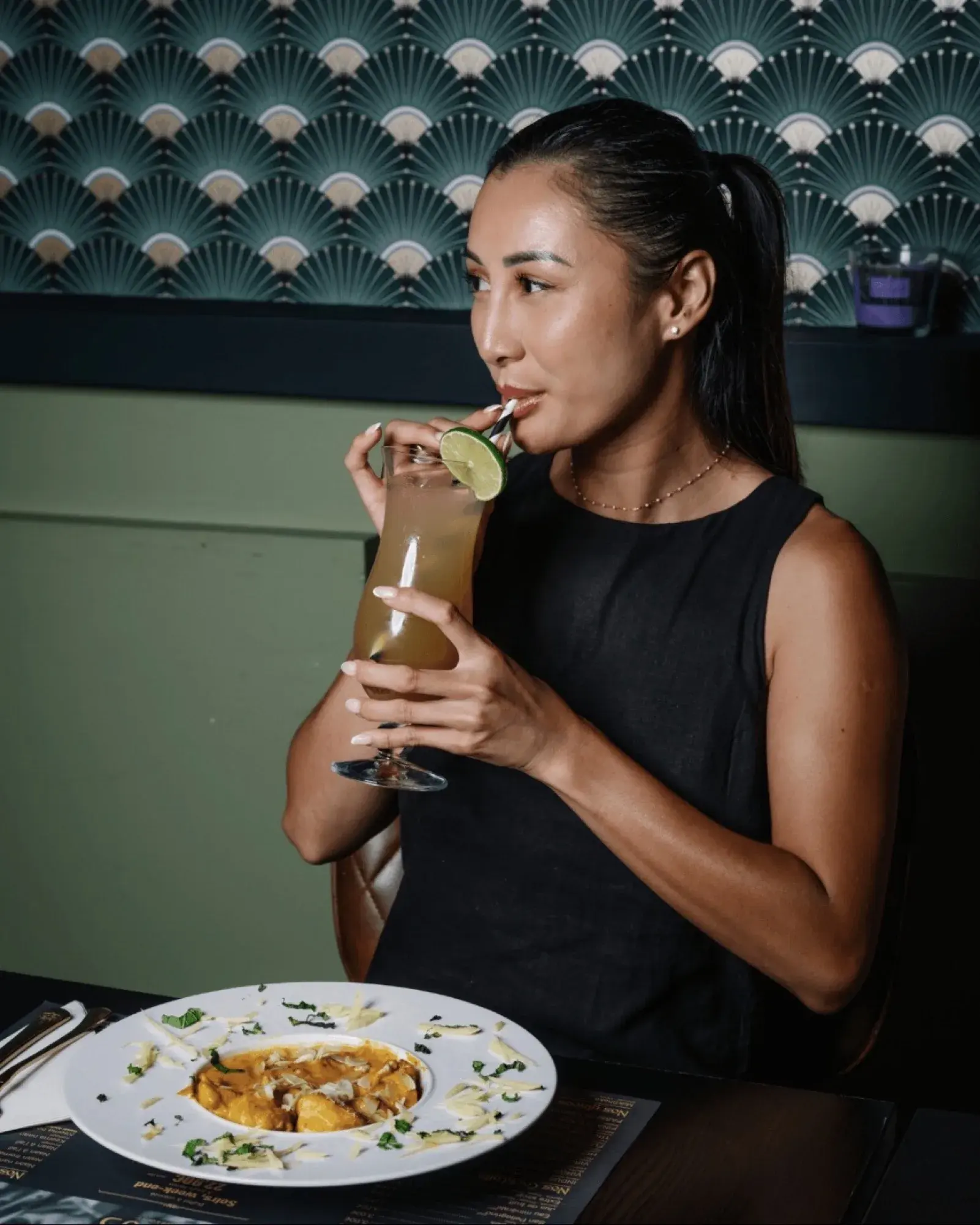 Dans un restaurant au décor art déco, cocktail siroté à la paille