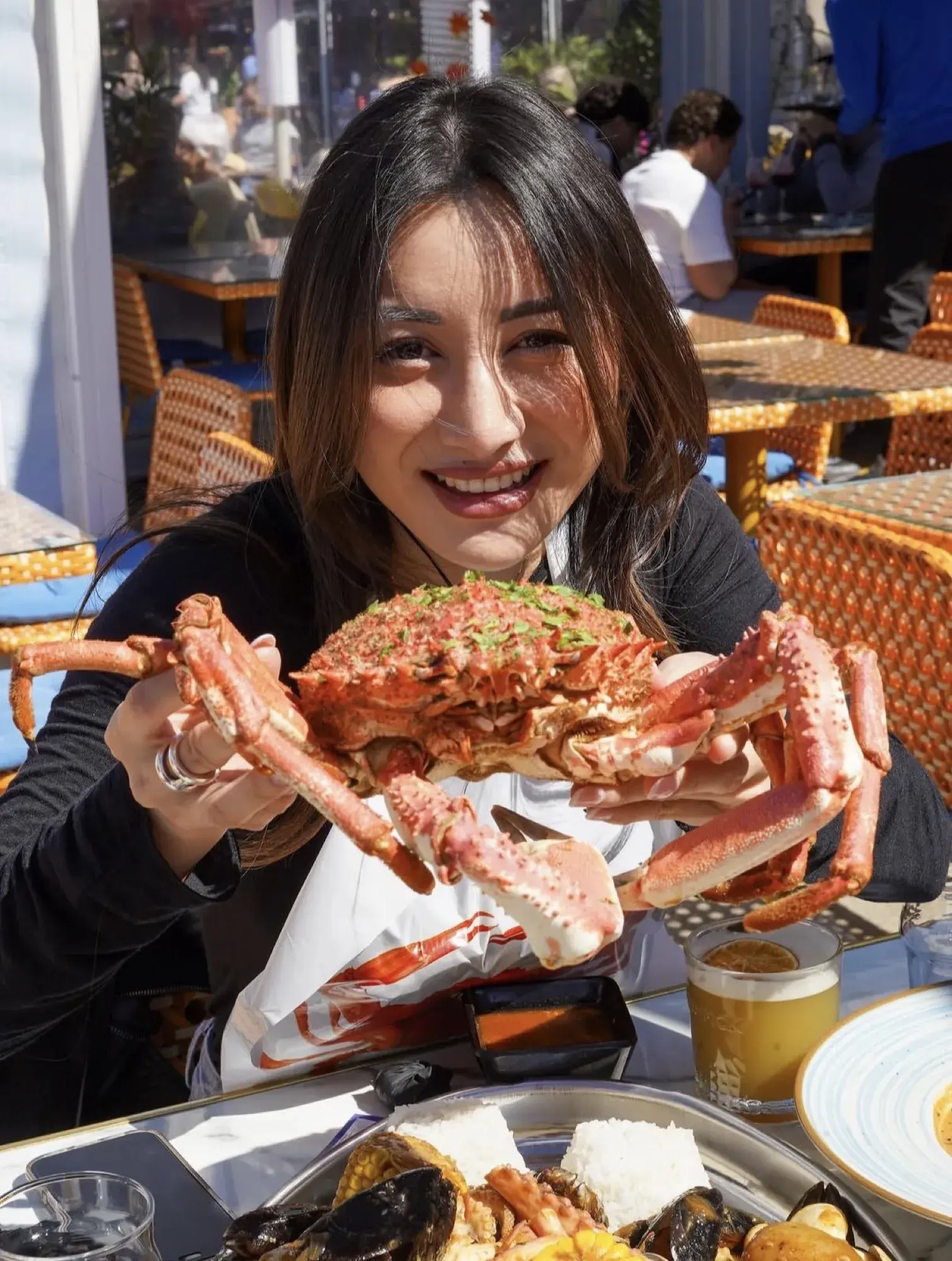 Terrasse ensoleillée de restaurant de fruits de mer, araignée de mer en main