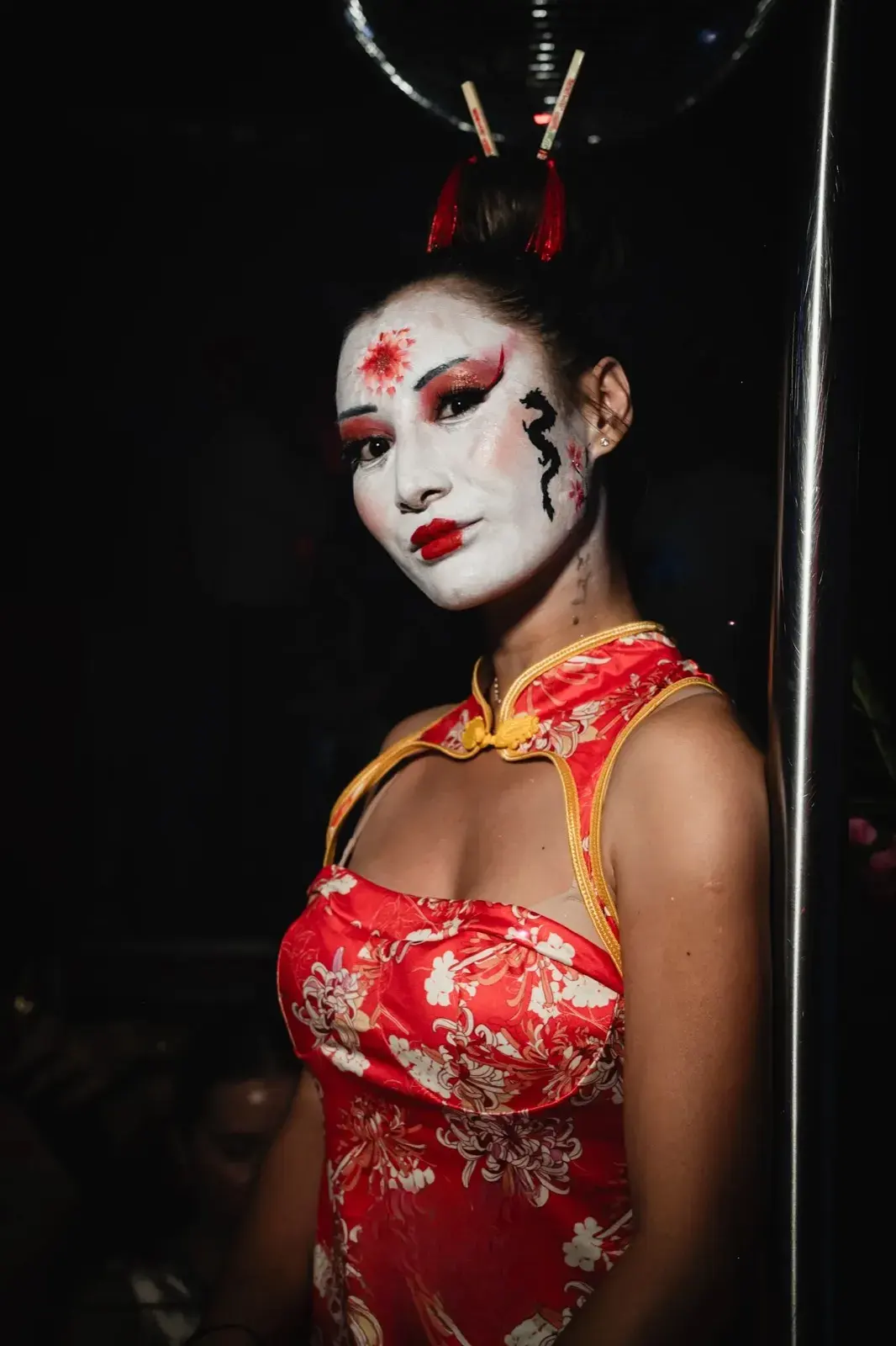Buste en tenue geisha rouge, maquillage fleur et dragon, regard caméra