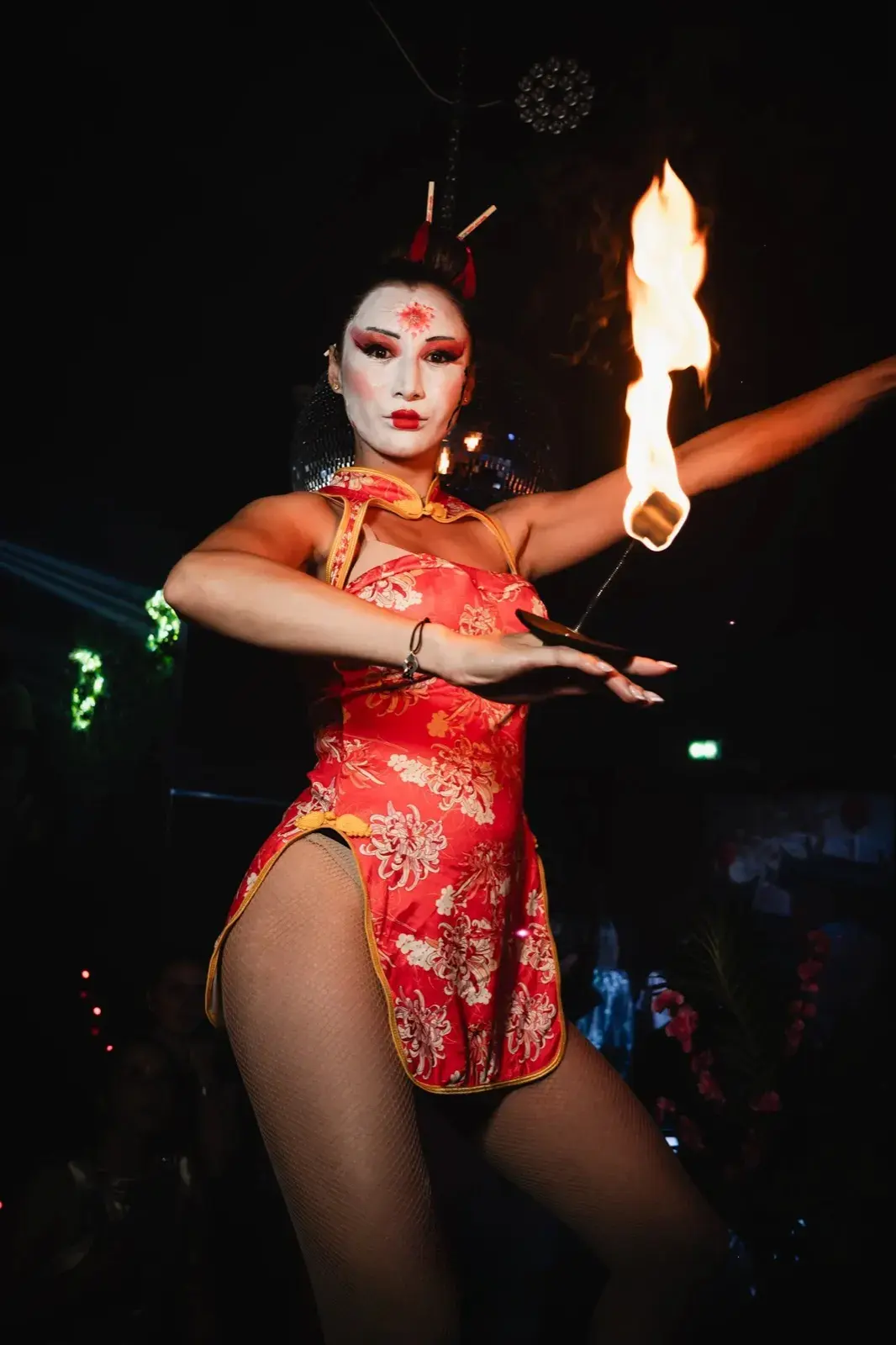 Performance avec éventail enflammé, mini-robe qipao fleurie