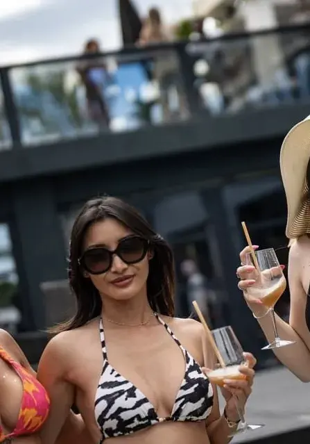 En bikini zébré, cocktail à la main, pool party estivale