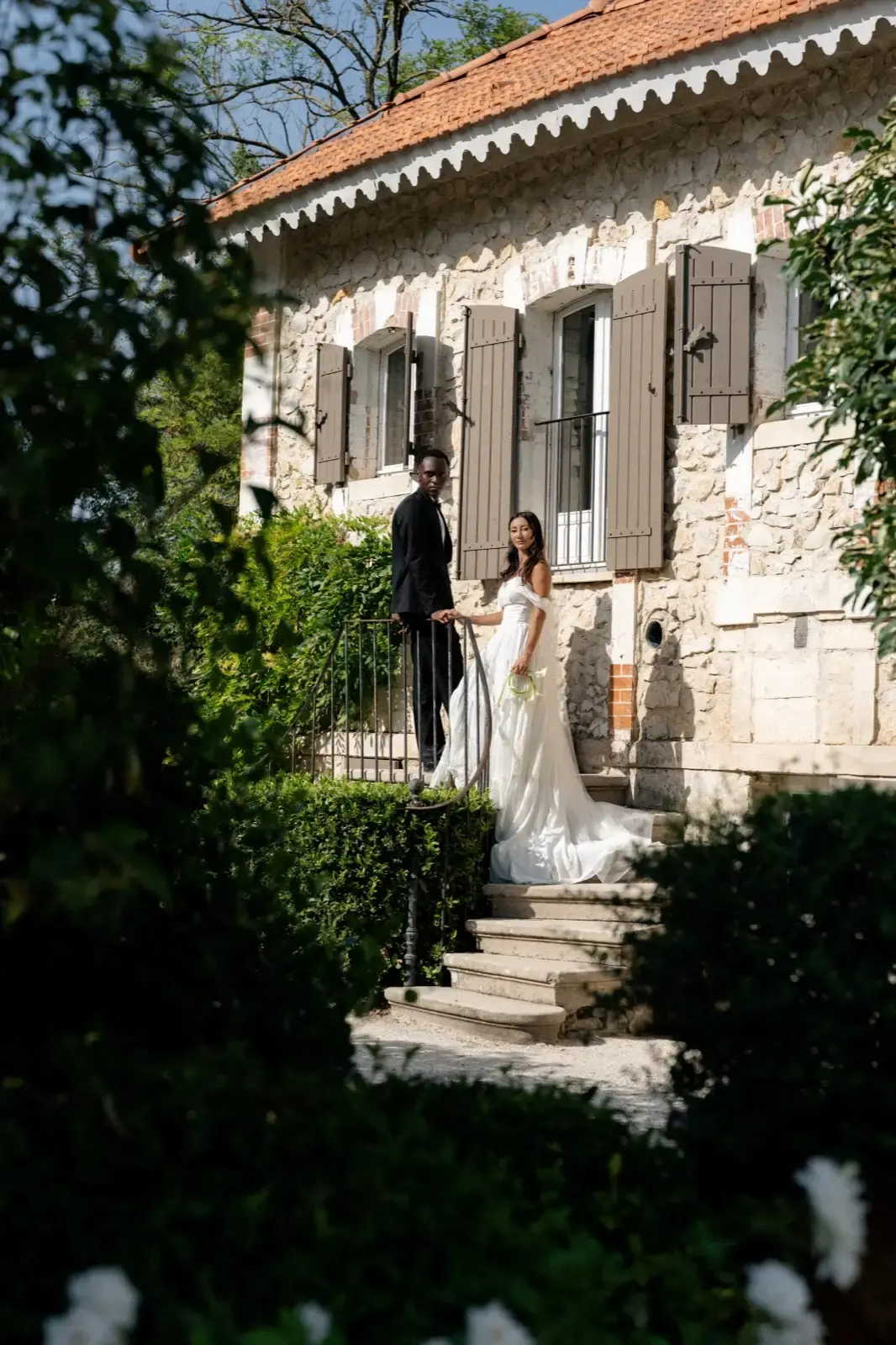 Les mariés sur l’escalier de la bastide, main dans la main