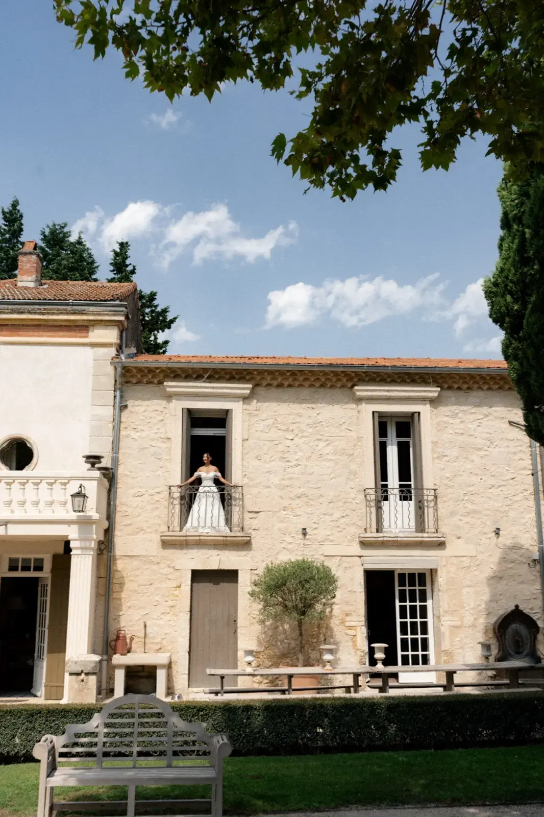 En pied devant les grilles, demeure en arrière-plan