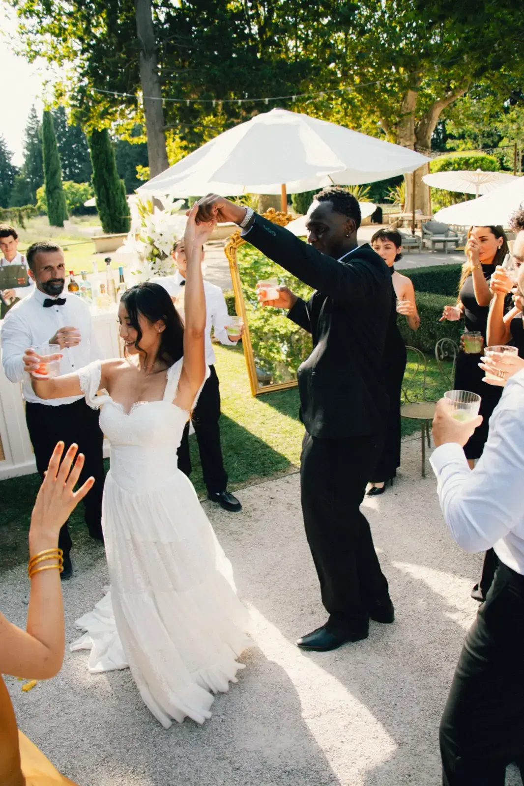 Bras levés, danse sous les arbres avec le marié