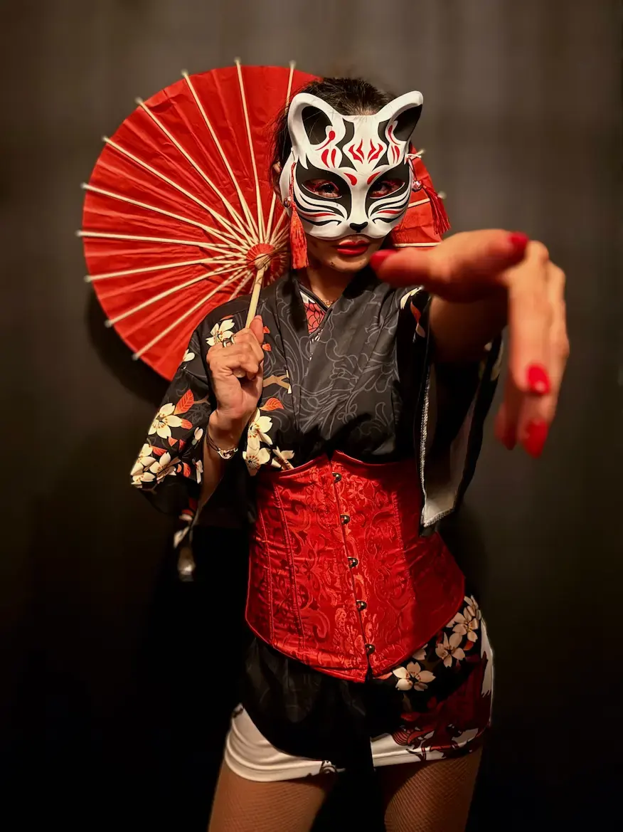 Masque kitsuné et ombrelle japonaise, kimono noir fleuri, main tendue