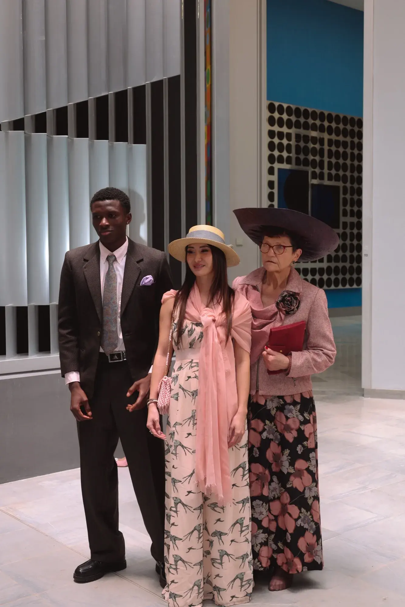 En robe imprimée et canotier avec deux mannequins dans un showroom