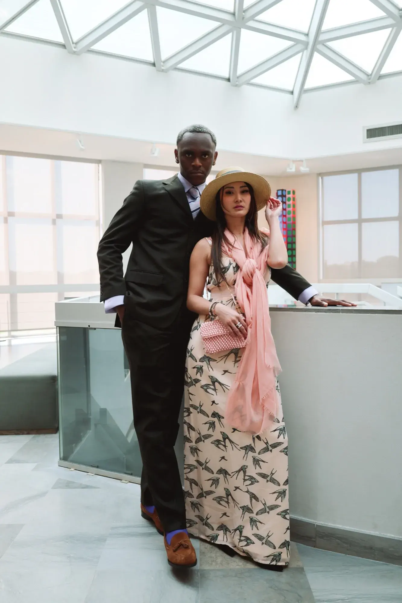 En pied tenant son canotier, duo dans le showroom