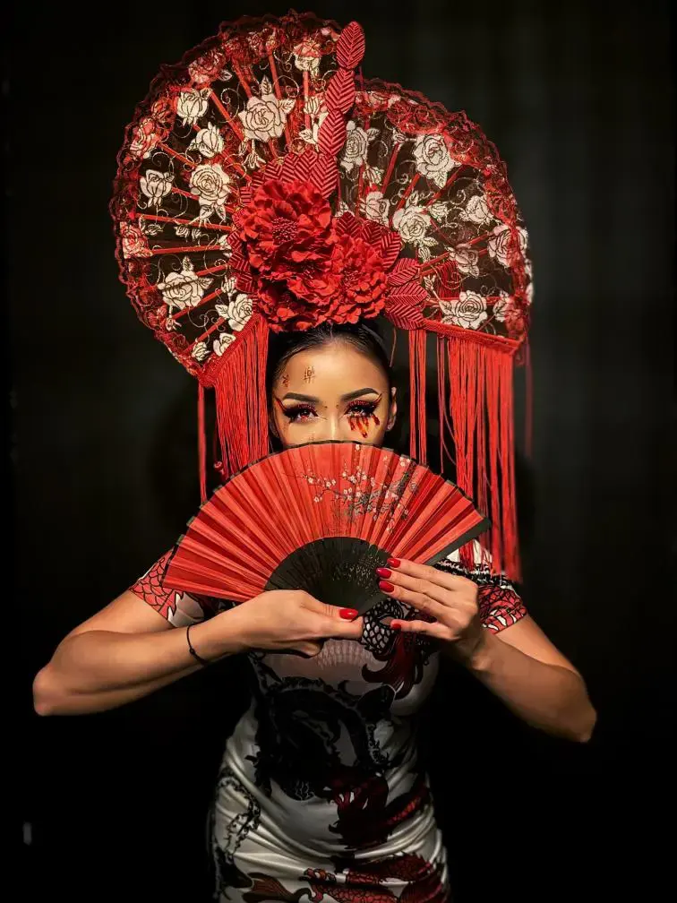 Portrait artistique, coiffe rouge en éventail de dentelle, éventail devant le visage